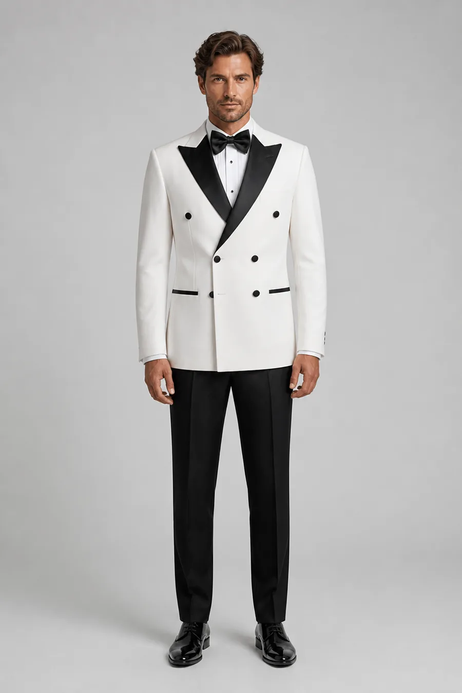 Model trägt Zweireiher-Smoking in Ivory mit schwarzer Satin-Spitzfassion von Harrison E Milano Berlin